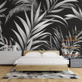 Black and white tropical palm leaf wallpaper in a modern minimalist living room with natural light and designer furniture