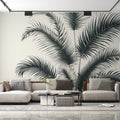 Black and white tropical palm leaf wallpaper creating a dramatic statement wall in a modern living room with minimal furniture