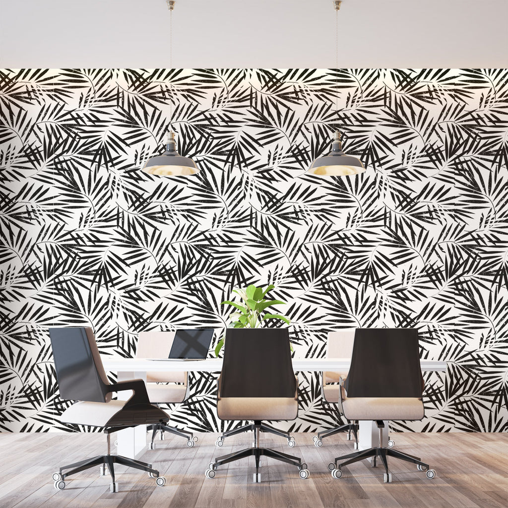 Black and white tropical palm leaf wallpaper creating a modern statement wall in a bright living room setting