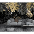 Tropical black and gold leaf wallpaper in modern living room showing dramatic marble effect and metallic accents