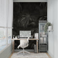 Tropical palm leaves wallpaper in modern living room with dark accent wall and minimal furniture