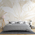 Tropical leaf wallpaper with white and gold design creating an elegant atmosphere in a modern living room