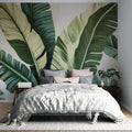 Tropical banana leaf wallpaper creating a stunning accent wall in a modern living room with natural light and minimal furniture