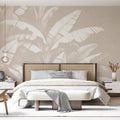 Tropical leaf wallpaper in modern minimalist living room showing large-scale banana leaves in white against soft beige