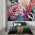 Pink and navy Monstera leaf wallpaper in modern living room with gray sofa and natural light