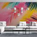 Tropical palm leaf wallpaper in pink and gold tones brightening a modern living room with natural light