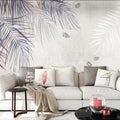 Tropical palm leaf wallpaper in modern living room showing watercolor style fronds in blue-grey tones
