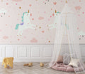 Unicorn wallpaper in a bright kids bedroom with pink curtains and white furniture showing magical ambiance
