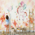 Unicorn wallpaper mural in a bright nursery, creating a magical atmosphere with soft watercolor flowers
